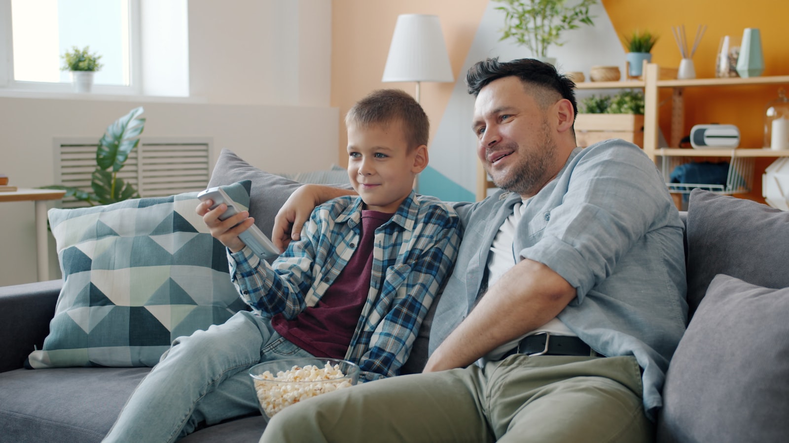 Father and son relaxing on the couch streaming a movie together