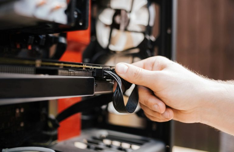 Crop faceless man fixing cables in system unit